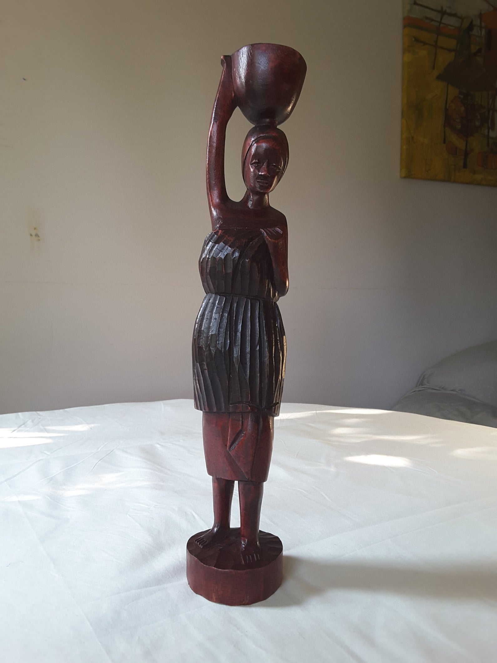 Wooden carving of an African woman with a baby on the back carrying a bucket of water-II